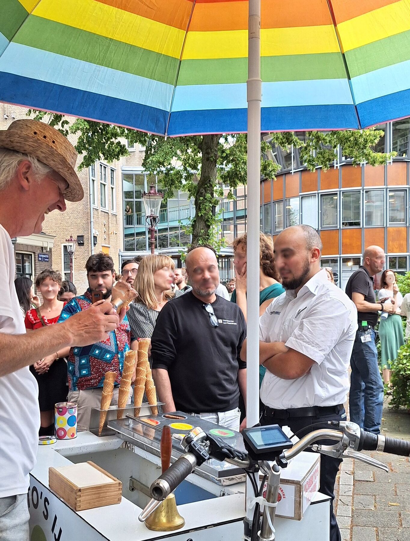 Ijsjes scheppen onder de regenboogparasol