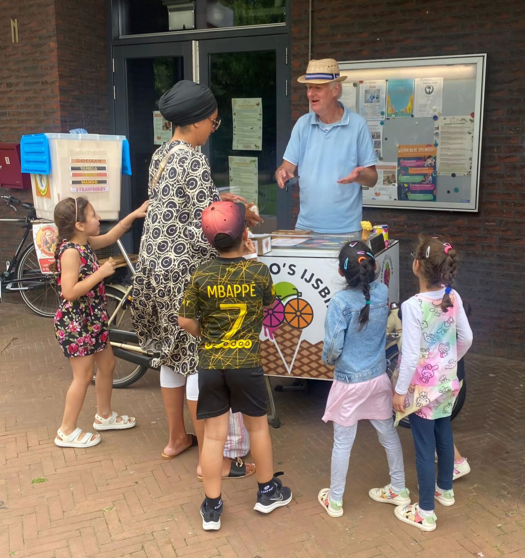Kinderen halen een ijsje bij de ijscokar