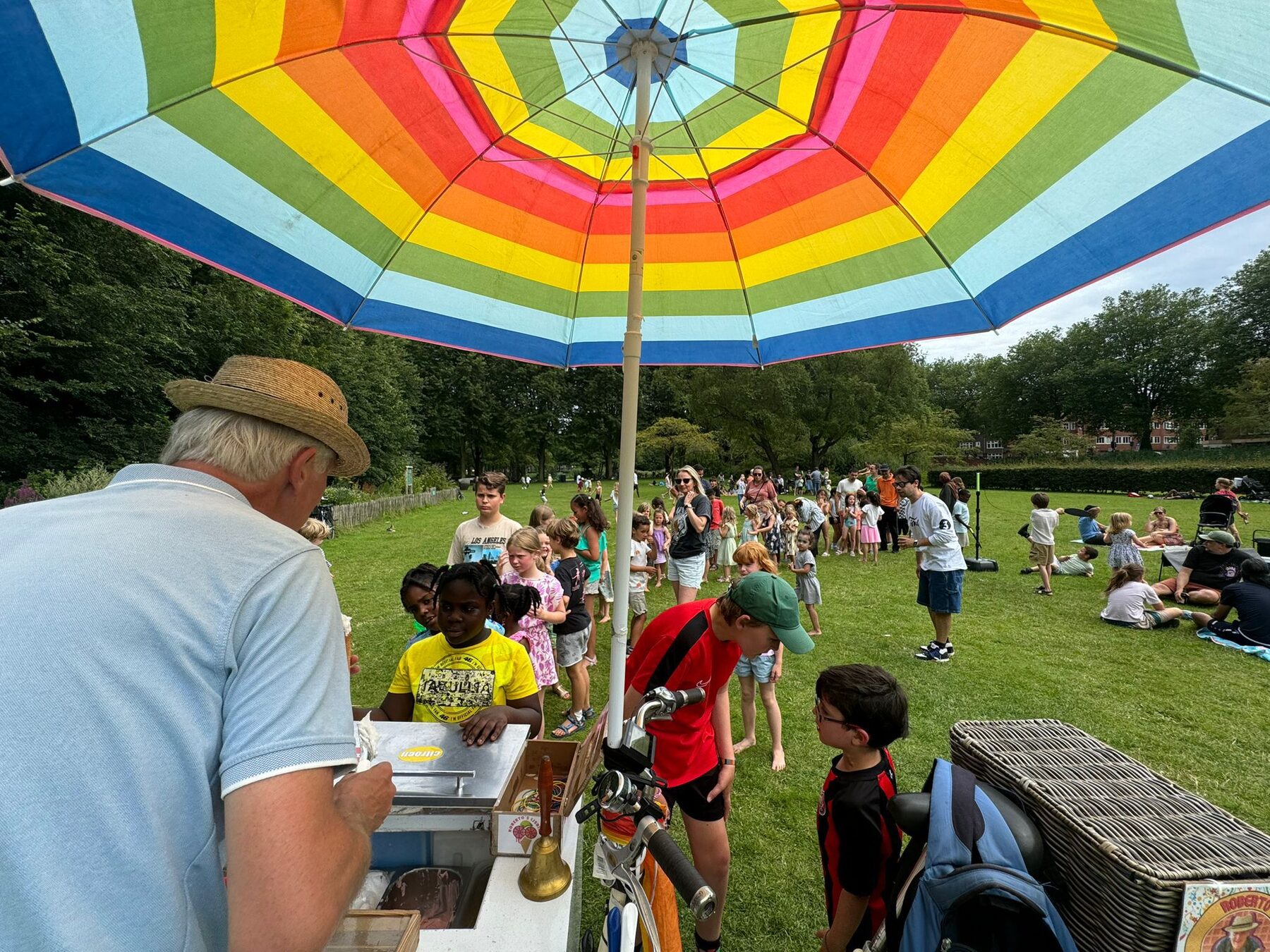 De ijscokar met regenboogparasol op een feest in het park
